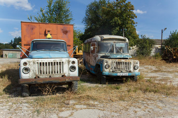 Fototapeta na wymiar Rusty abandoned soviet widespread bus kavz 685 and abandoned soviet truck 