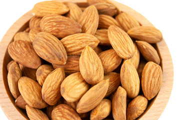 Almonds in a wood bowl on white background