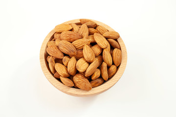 Almonds in a wood bowl on white background