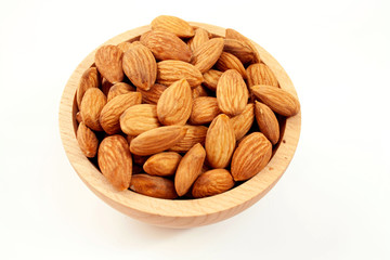 Almonds in a wood bowl on white background