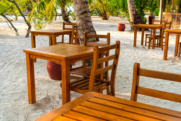 Wooden table and chairs by the tropical warm sea. Maldives