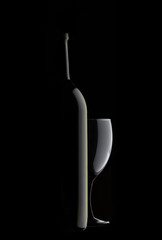bottle of wine and a glass on a black background