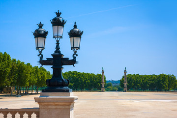 Fototapeta na wymiar Antique street lamp and columns near the Girondins memorial in Bordeaux, France