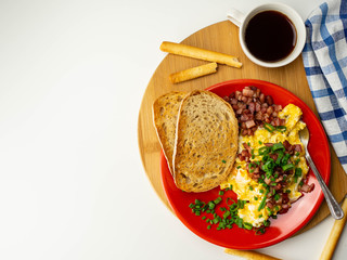 Śniadanie białkowo-tłuszczowe. Jajecznica, boczek, grzanki, szczypiorek. Widok z góry.