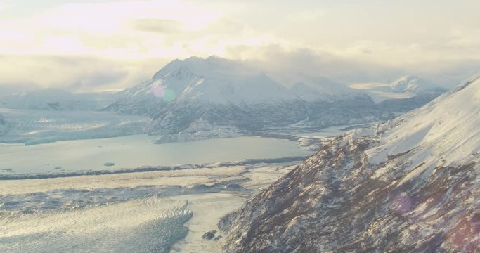  Aerial helicopter shot, pan across vast glacial valley at golden hour, drone footage
