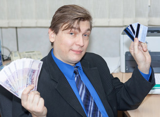 the cheerful manager holds several credit cards and a wad of money