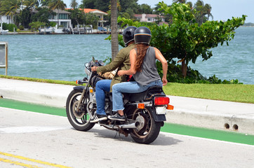 Couple riding tandem on a motorcycle  crossing the Venetia Causeway near Miami Beach,Florida
