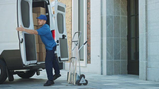 Delivery Man Uses Hand Truck Trolley with Cardboard Boxes, Packages, Loads Parcels and closes Truck / Van Doors. Professional Courier / Loader helping you Move, Delivering Purchased Items Efficiently