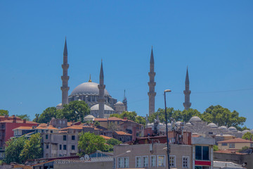Fototapeta na wymiar Suleymaniye Mosque and houses in front. Blue sky and sunny day.