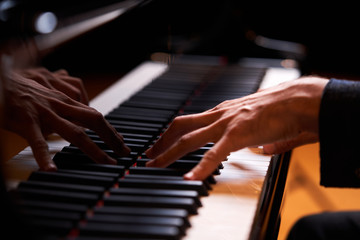 Fototapeta na wymiar Closeup man's hand playing piano. Music performer's hand