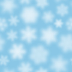 Christmas seamless pattern of white defocused snowflakes on light blue background