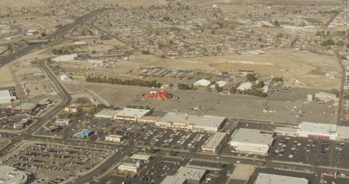 Aerial shot, day, high altitude zoom in on circus tent in parking lot, drone