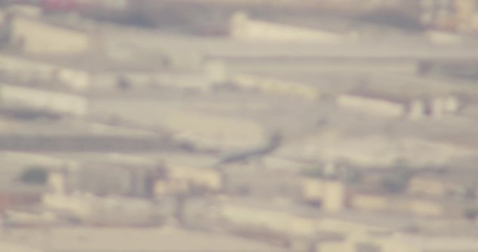 Aerial helicopter shot, zooming out while tracking airliner soaring above LA city blocks, zoom way out to show the plane's miniscule scale, drone footage