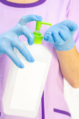 dispenser with disinfectant. gloved hands. use of a disinfectant in medicine, cosmetology