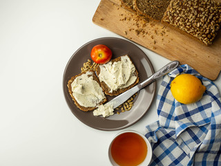 Kanapki z serkiem z ziołami, pomidorem i słonecznikiem. Widok z góry.