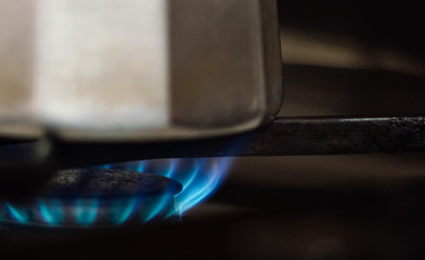 Close-up of Steel Coffee Maker on a Gas Cooker with Blue Flame.
