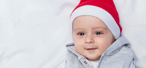 Little Santa. 1 year old baby boy in Santa Claus cap. Christmas kids