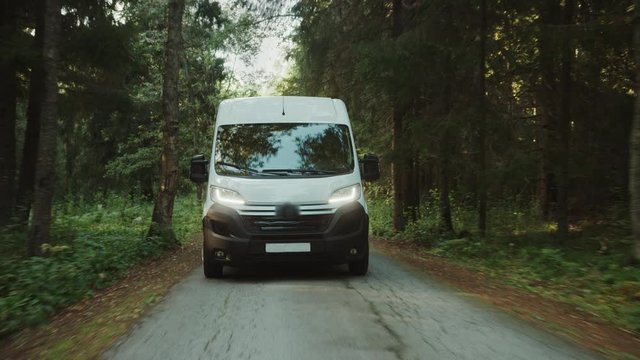 New Delivery Van / Truck Driving Through the Green Woods. Postal Delivery Service. Front View Following Shot