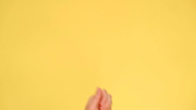 Female hand pointing on copyspace isolated over yellow background in studio. Body language concept. With place for text or image, promotional content. Advertising area, workspace mock up