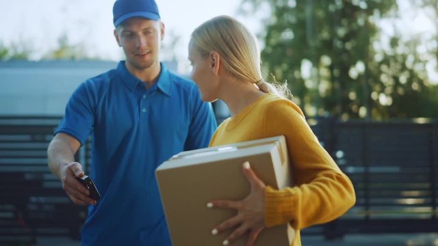Beautiful Young Woman Meets Delivery Man who Gives Her Cardboard Box Package, She Signs Electronic Signature POD Device. Courier Delivering Parcel in the Suburban Neighborhood 