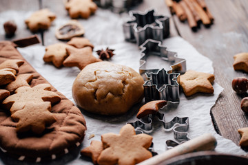 Freshly baked appetizing homemade gingerbread cookies, raw dough, baking utensils and food decorations. Christmas and New Year celebration traditions. Family home bakery, cooking festive sweets