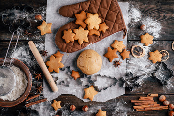 Freshly baked appetizing homemade gingerbread cookies, raw dough, baking utensils and food...