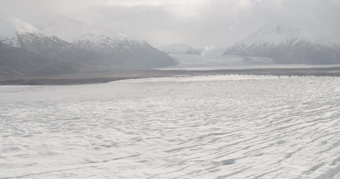 Aerial shot, day, beautiful panorama of glacier in valey, mountains in distance, drone