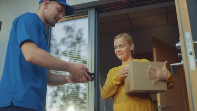 Beautiful Young Woman Opens Doors of Her House and Meets Delivery Man who Gives Her Cardboard Box Postal Package, She Signs Electronic Signature POD Device. Slow Motion Low Angle