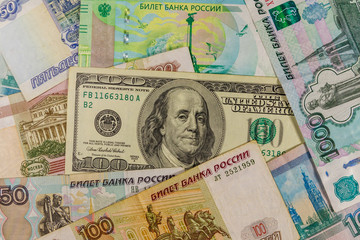 Fototapeta na wymiar One hundred dollar bill on a background of russian rubles banknotes