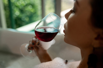 Close-up photo of brunette posing with a glass of wine