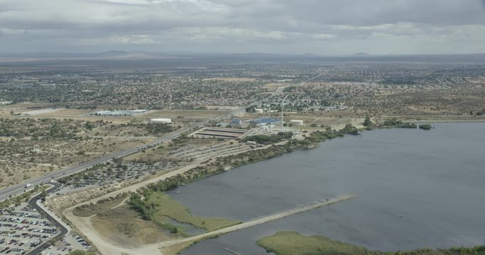 Aerial shot, day, high altitude view of desert lake and surrounding business/residental area, drone