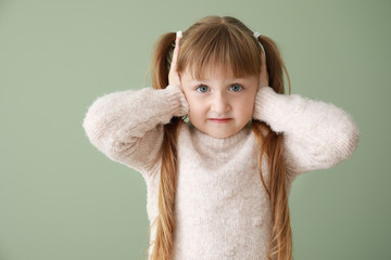 Portrait of stressed little girl on color background