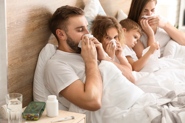 Family ill with flu in bed at home - obrazy, fototapety, plakaty