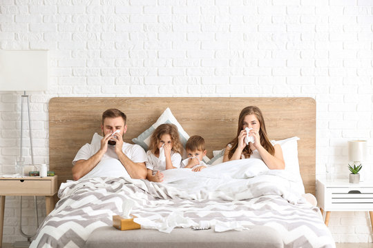 Family ill with flu in bed at home