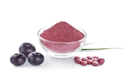 Bowl with acai powder and tablets on white background