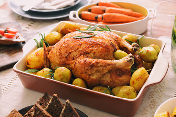 Baking dish with tasty chicken and potato on served table