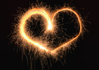 Heart made of sparkler on dark background