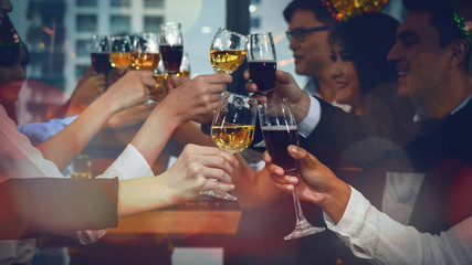 group of business people enjoying party and clinking glass of champagne and wine together to...