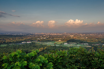 Natural panoramic scenery background, which can see the surrounding atmosphere (trees, green leaves, mountains, fog, soft sunlight, colorful sky) with blurred wind blowing, cool air