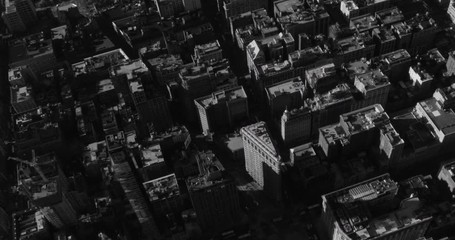 Black and white aerial shot, zoom in on Flatiron building, end pan on Madison Square park, drone