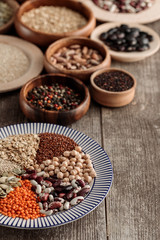 wooden and ceramic plates with legumes and cereals on table