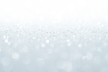 Silver Sparkling Lights Festive background with texture. Abstract Christmas twinkled bright bokeh defocused and Falling stars. Winter Card or invitation