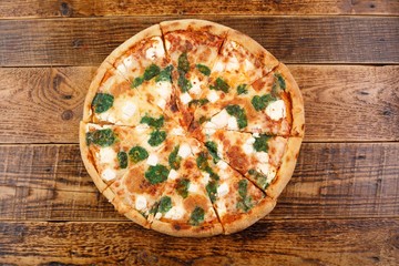Hot four cheese delicious pizza with a thick crust on a wooden background.