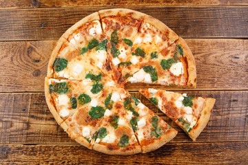 Hot four cheese delicious pizza with a thick crust on a wooden background.