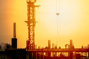 Crane construction over building site on sunset sky in the evening