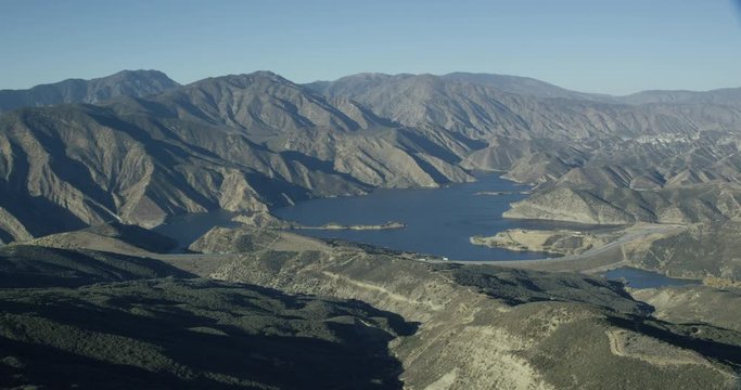 Helicopter aerial shot panning over lake and mountains, day, drone