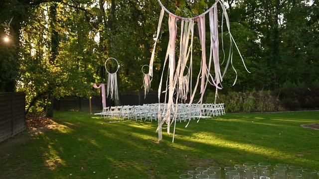 Wedding ceremony decoration on wind. Wind blows colorful ribbons in spring sunlight