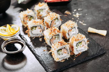 Macro shot of uramaki sushi rolls with cream cheese, fried salmon, tuna shavings or dried bonito, cucumber, nori. Fresh katsuobushi roll in Japanese restaurant closeup