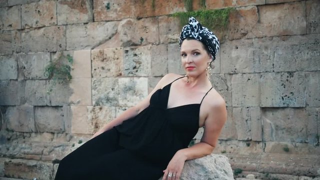 Beautiful young attractive Muslim woman in long black dress standing on the corner of Hidirlik tower, historical place