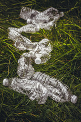 Plastic bottles in the green grass. Problem in the natural environment.
